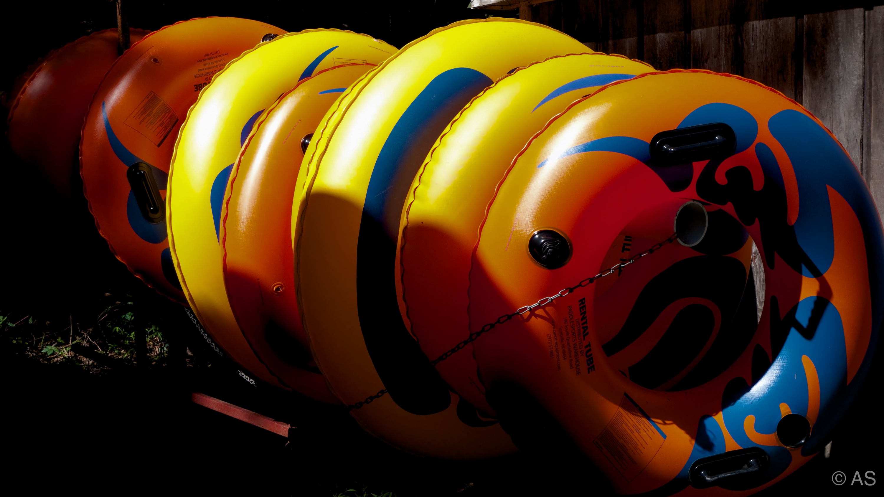 Stack of colourful inflatable rubber rings leaning against a dark wall